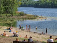 People enjoy sunny and warm spring weather sunbathing and swimming in Otominskie lake in Kashubia region, Poland. Meteorologists predict tem...