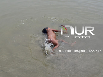 An indian kid takes bath in Ganges river to beat the heat, during a hot day in Allahabad on May 23,2016. (