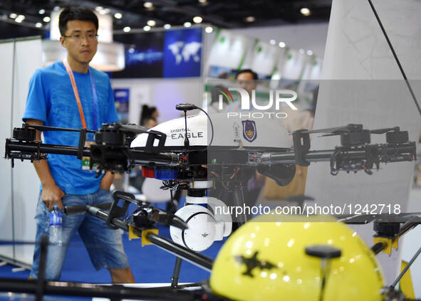 A man looks at a police unmanned aerial vehicle at the fourth China Beijing International Fair for Trade in Services in Beijing, capital of...