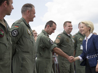 German Defense Minister Ursula von der Leyen (R) shake hands with a member of the Luftwaffe, the German air force, during a visit at the ILA...