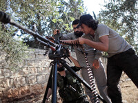 Free Syrian Army fighters prepare a heavy weapon in order to fight forces loyal to Syria's President Bashar al-Assad in the Khan al-Assal to...