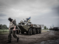 Soldier passes the APC on the check-point next to Slaviansk city, on May 31, 2014. Over 20 Ukrainian army personnel have been killed during...