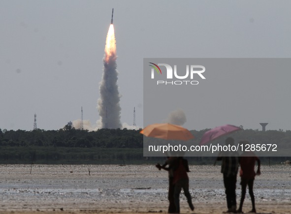 People watch the launch of Indian Space Research Organization's Polar Satellite Launch Vehicle (PSLV) carrying the satellites in Sriharikota...