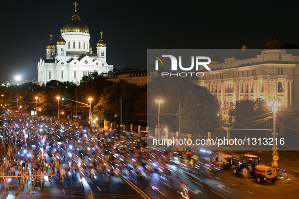 Participants ride along a street during the night cycling parade in Moscow, Russia, July 3, 2016. Over 10,000 people took part in the 2nd Mo...