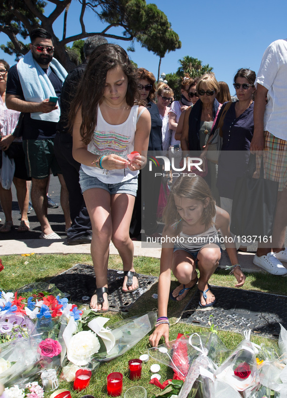 People offer flowers and candles to the victims near the site of the terrorist attack in Nice, France, July 15, 2016. The death toll rises t...