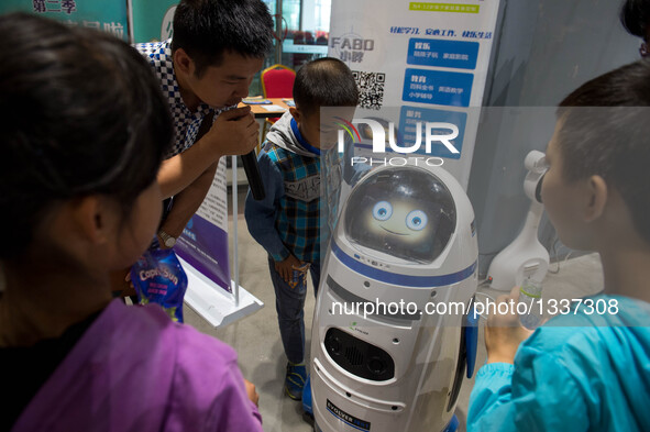 Visitors communicate with a robot during a robot carnival and summer youth camp in Kunming, capital city of southwest China's Yunnan Provinc...