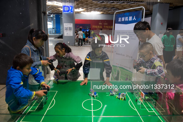 Children control robots in a football competition during a robot carnival and summer youth camp in Kunming, capital city of southwest China'...