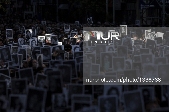 People hold victims' pictures during a commemoration of the 22nd anniversary of a terrorist attack on a Jewish center in 1994 in Buenos Aire...