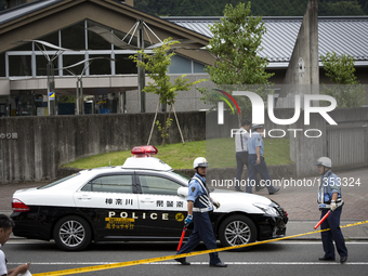 Police officers guard the front of gate as they continue to investigate on knife attack in a handicap center in Tsukui Yamayuri-en building...
