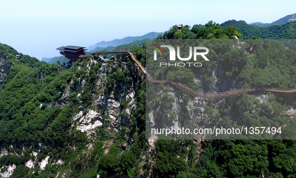A wooden pathway, including 69 meters of which paved with glass, is seen along the face of a cliff in Shaohuashan national forest park in We...