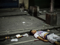 (EDITORS NOTE: Image depicts graphic content.) The corpse of a suspected drug pusher lies on a street after he was shot dead by unidentified...