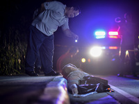 (EDITORS NOTE: Image depicts graphic content.) A member of the police's homicide division inspects the corpse of a suspected drug addict and...