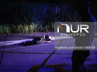 (EDITORS NOTE: Image depicts graphic content.) A police investigator inspects the corpse of a suspected drug addict and victim of a vigilant...