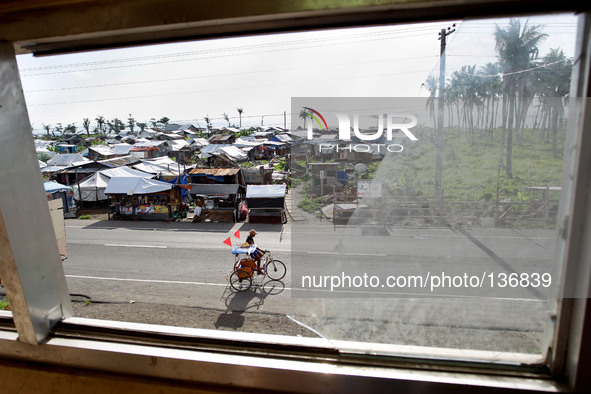Tacloban, Philippines - A pedicab is seen passing by through a broken glass window in Tacloban City on June 11, 2014. On November 8, 2013, H...