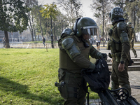 Riot police checked the backpack of a protester.


Chilean students, convened by the Confederation of Chilean Students, known as CONFECH,...