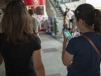 Teenage play with gaming app Pokemon Go at Siam Paragon shopping mall to catching Pokemon Bangkok Thailand, on August 6, 2016.  (