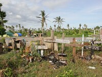 Tanauan, Philippines - A pedicab goes past a mass grave along the highway in Tanauan Leyte on June 11, 2014. On November 8, 2013, Haiyan, on...