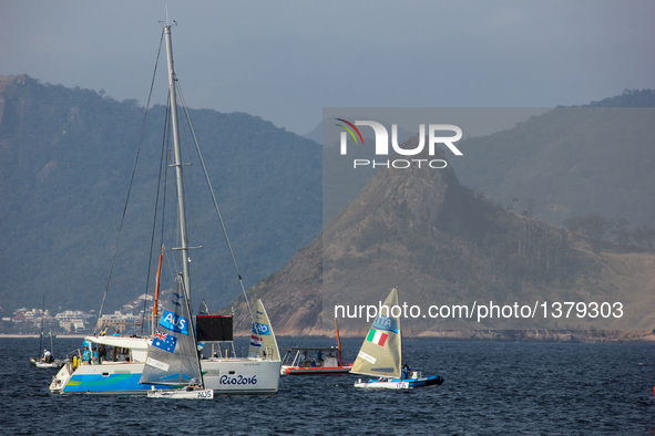 Finn sailing race at the 2016 Summer Olympics Rio in Rio de Janeiro, Brazil. Brazilians and foreigners enjoy the Flamengo beach, which is ba...