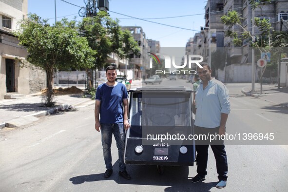 Palestinian students Jamal Mikaty (R) and Khaled Bardawil stand next to their solar car in Gaza City, on Aug. 16, 2016. Two Palestinian mech...
