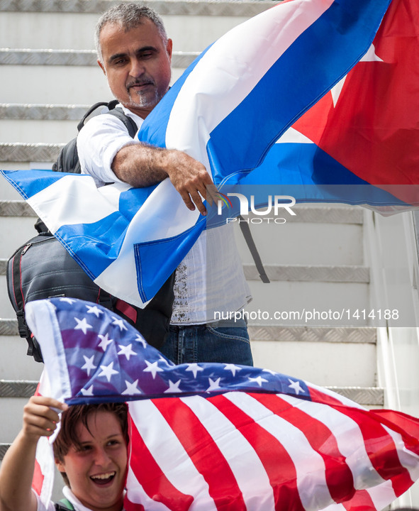 Passengers from the first commercial flight from U.S., pose for pictures with national flags of Cuba and the U.S., at the Abel Santamaria In...