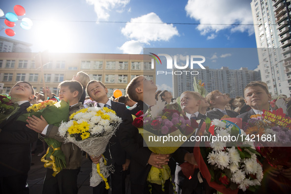 Students holding flowers attend a ceremony marking the beginning of a new school year in Moscow, capital of Russia, on Sept. 1, 2016. Sept....