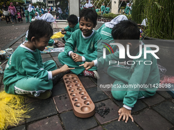 Three childern play traditional games ' dakon' in Yogyakarta, Indonesia, on 9 September, 2016. This event to give learning activities on tra...
