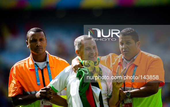 (140617) -- BELO HORIZONTE, June 17, 2014 () -- A fan (C) is escorted by the security guards as he jumped into the pitch prior to a Group H...
