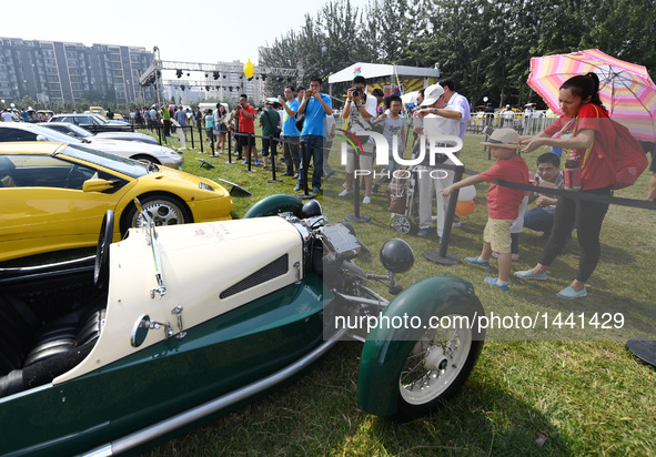 Visitors watch vintage cars during a vintage vehicle fair in Beijing, capital of China, Sept. 15, 2016. More than 100 vintage vehicles were...