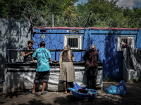 Refugees women while doing laundry at a makeshift refugee camp on the Serbian side of the border with Hungary near the town of Horgos on Aug...