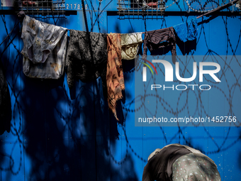 A refugee woman hangs out laundry at a makeshift refugee camp on the Serbian side of the border with Hungary near the town of Horgos on Augu...
