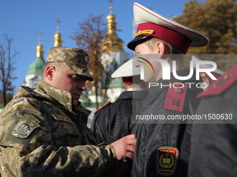A serviceman adjusts his cadet military form before the ceremony of bringing of the solemn oath in front of St. Sofia Cathedral in Kiev. Ukr...