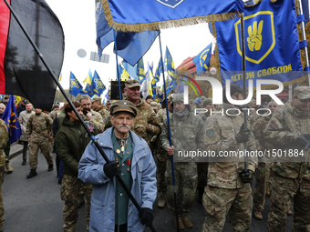  UPA veteran carries a flag as Ukrainians celebrate the 74th anniversary of Ukrainian Insurgent Army (UPA) creation in downtown Kyiv, Ukrain...