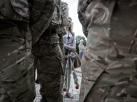 A girl stands behind combatants as she comes to attend her boyfriend departing to ATO zone with Azov battalion (