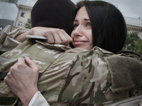 A girl cuddles her boyfriend as she comes to attend him departing to ATO zone with Azov battalion (