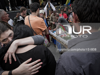A girl gives solace to a relative of dead Euromaidan activist (