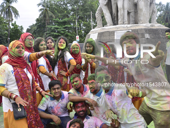 Dhaka University's Pali and Buddhist Studies department's students dance to music and apply colored paint powder as they celebrates Rag Day...