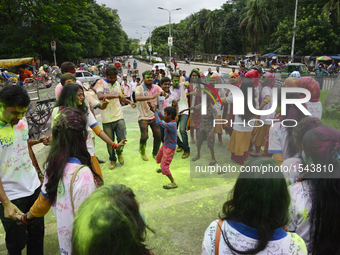 Dhaka University's Pali and Buddhist Studies department's students dance to music and apply colored paint powder as they celebrates Rag Day...