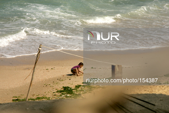 A Palestinian girl playing in the sands of the seashore in the central Gaza Strip on June 26, 2014. Palestinian Environment Quality Authorit...