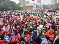 Bangladeshi School students rise up textbook with Education Minister Nurul Islam Nahid during the Textbook Festival Day in Dhaka, Bangladesh...