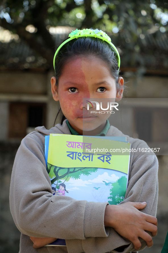 An indigenous girl hold new textbooks, pose for photograph in Bandarban in Chittagong, South-Eastern Bangladesh on January 1, 2017. Over fou...
