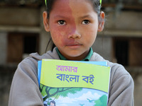 An indigenous girl hold new textbooks, pose for photograph in Bandarban in Chittagong, South-Eastern Bangladesh on January 1, 2017. Over fou...