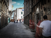In the background a group of students walking along the historic center of L'Aquila on July 2, 2014, severely damaged after the quake of Apr...