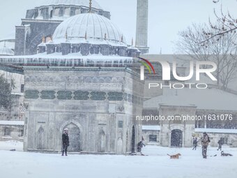 People walk during snowfalls in Istanbul on January 7, 2017. A heavy snowstorm paralysed life in Istanbul with hundreds of flights cancelled...