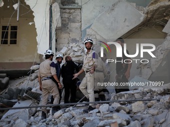 Members of the Syrian Civil Defence loyal to the Free Syrian Army inspect the rubbles after what activists said it was a barrel-bomb by airc...