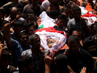 Palestinians carry the bodies of members of the Hamad family during funeral in town of Beit Hanoun in the northern Gaza Strip on July 9, 201...