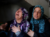 Palestinian relatives of the members of the Hamad family mourn during funeral in town of Beit Hanoun in the northern Gaza Strip on July 9, 2...