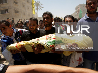 Relatives and friends of the al-Kaware family carry one of the 7 bodies to the mosque during their funeral in Khan Yunis, in the Gaza Strip,...