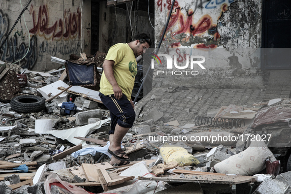 A man walking on wreckage of a destroyed house after Israeli Airstrike in Gaza, on July 10, 2014. Israeli warplanes pounded Gaza today, kill...