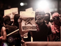 Bahrain , Abu Saiba - protester raising a poster written on it 
