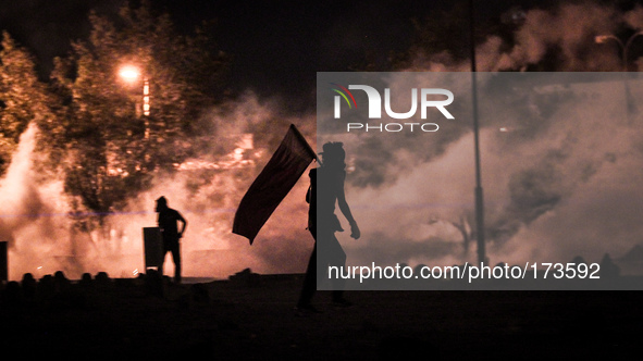 Bahrain , Abu Saiba - protester holding Bahrain flag during the clashes with riot police , demonstration with title 